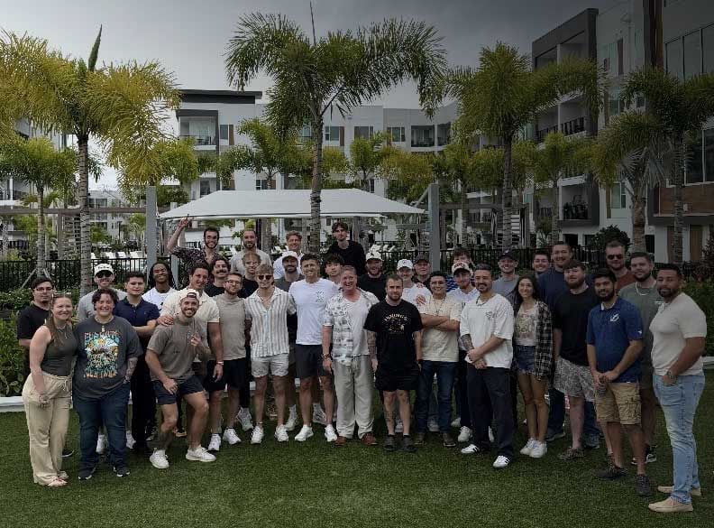 Epic Life agents and staff standing together outdoors on a lawn, smiling.